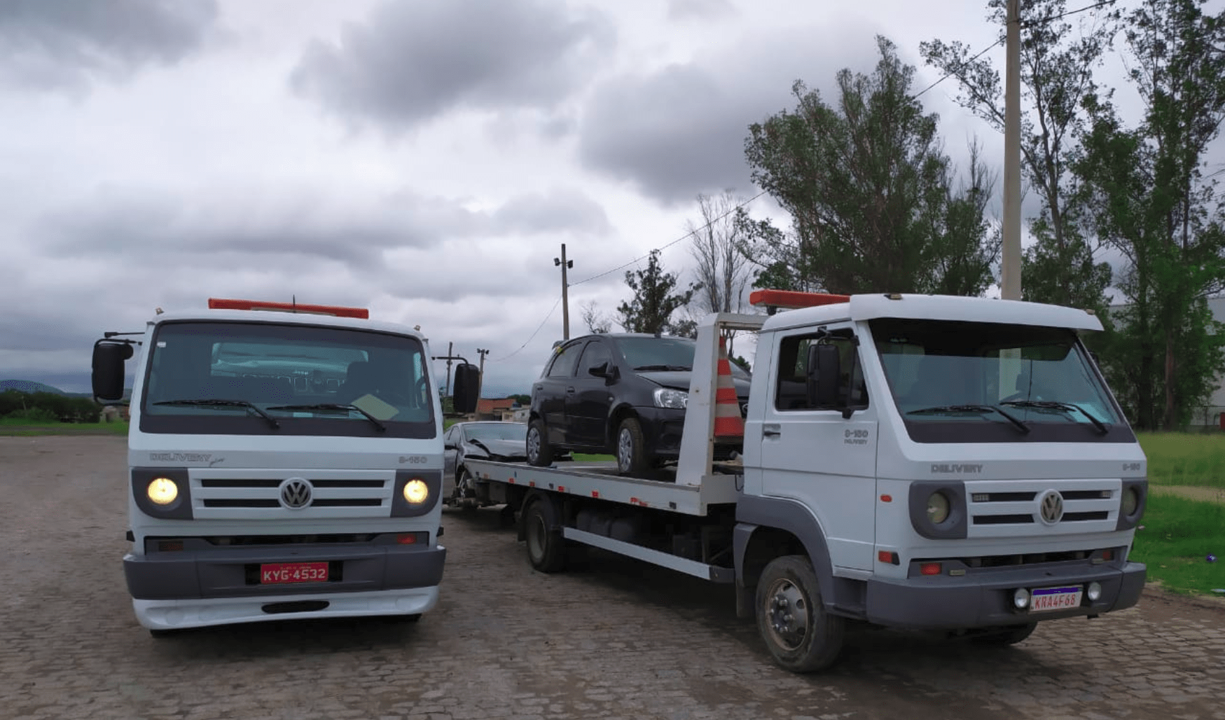 dois caminhões reboque transportando carros