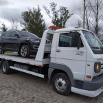 Caminhão guincho plataforma transportando um Jeep no Rio de Janeiro